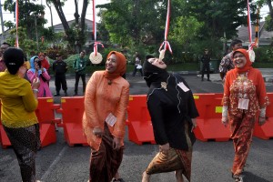 LOMBA MAKAN KRUPUK. Sejumlah peserta mengikuti lomba makan kerupuk saat peringatan hari Kartini di Balai Kota Surabaya, Jawa Timur, Selasa (21/4). 